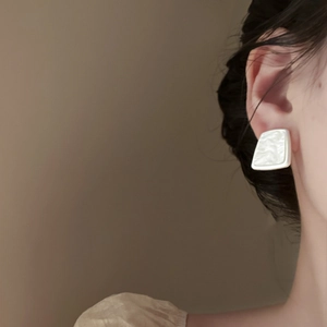 French vintage pearl white geometric resin stud earrings worn on a model's ear