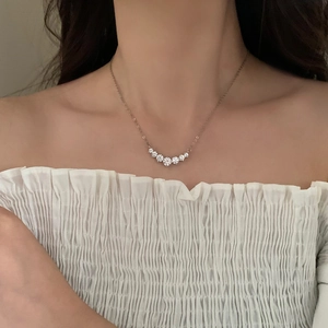Close-up of sparkling seven-stone zircon smile necklace worn on a woman neck