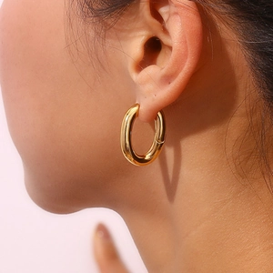 Close-up of 18K gold plated hoop earrings worn by a model to show elegant fit and shine