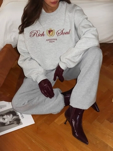 Λεπτομέρεια γκρι φούτερ oversize με στάμπα Rich Soul και μπορντό δερμάτινα γάντια