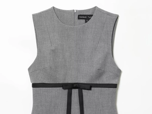 Close-up of gray sleeveless dress featuring woven texture and black bow tie at the waist