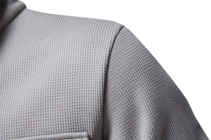 Close-up of grey waffle knit fabric texture and seam detail on a men cardigan jacket