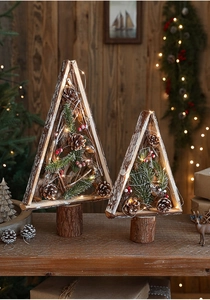 Detail of wooden Christmas tree decor with pine cones, needles and warm LED string lights