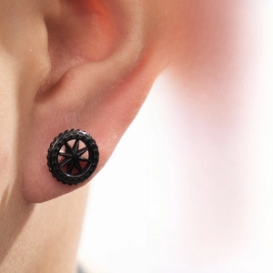 Macro detail of black industrial gear stud earring in a trendy geometric star design