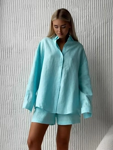 Detailed texture of light blue linen long-sleeve shirt and matching shorts on model