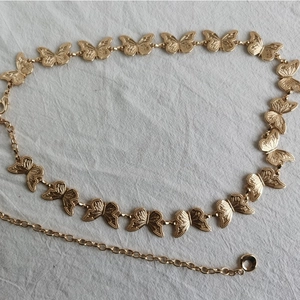 Close-up of golden butterfly metal waist chain with lobster clasp and adjustable extender