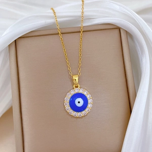 Elegant gold evil eye necklace with blue center and sparkling crystals on silk