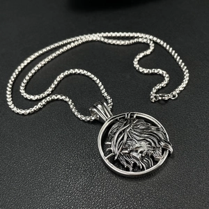 Vintage stainless steel lion head pendant with thorn crown on black texture background
