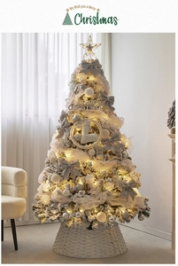 Dettaglio di un albero di Natale bianco con punta a stella dorata e luci a LED calde