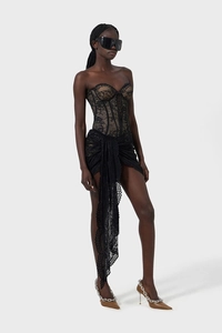 Dettaglio del corsetto in pizzo nero e della gonna irregolare con motivi floreali fini
