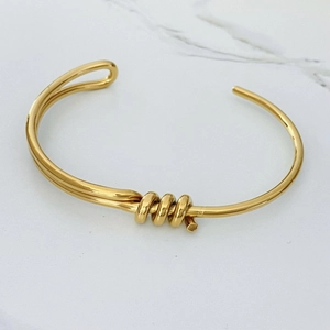 Gros plan du bracelet jonc doré en acier inoxydable avec détails polis effet miroir