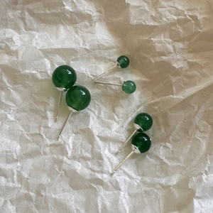 Three sizes of green agate stud earrings with silver pins on a paper background