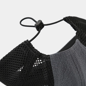 Detail of adjustable elastic drawcord and toggle on breathable mesh outdoor cap