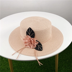 Detailed view of women's boater straw hat with 3D fabric flower and gold leaf embroidery