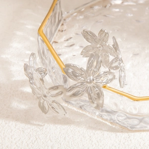 Macro shot of the delicate transparent flower-shaped jewelry accessory on a gold-rimmed tray