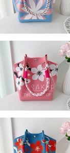 Detailed view of knitted tote bags with floral patterns and Sakura text design