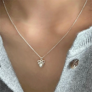 925 Sterling silver bow necklace with pearl pendant shown on model neck for elegant look