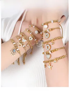 Detailed view of layered 18K gold plated beaded bracelets with heart and star charms