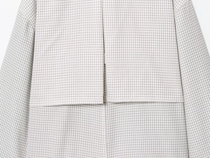 Vue macro du rabat arrière à motif quadrillé sur ce trench-coat court élégant