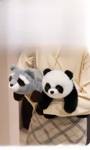 Close-up of soft plush panda and raccoon dolls held to show fluffy material and scale