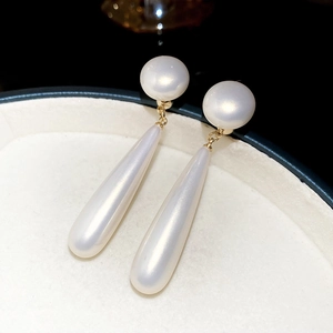 Close-up of elegant 18k gold plated drop earrings with round and long teardrop pearls