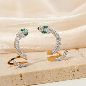 Luxurious gold snake earrings with white crystals and emerald green gemstone eyes