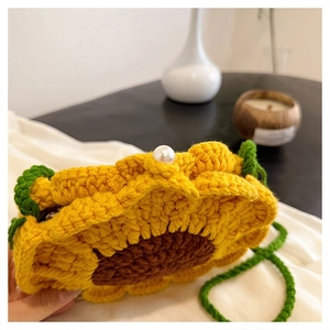 Close-up of handmade crochet sunflower crossbody bag with pearl button closure detail