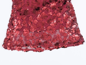 Close-up of red sequins stitched on mesh fabric showing texture of the party dress