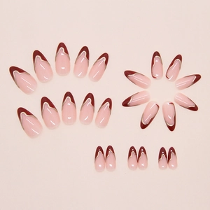 Macro detail of almond-shaped wine red French press-on nails with golden wavy edges