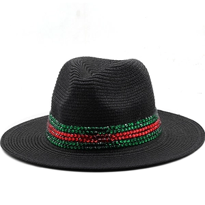 Close-up of black straw fedora featuring green and red rhinestone decorative band details