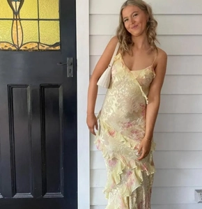 Détail de la robe fleurie jaune montrant des volants multicouches et un imprimé éclatant