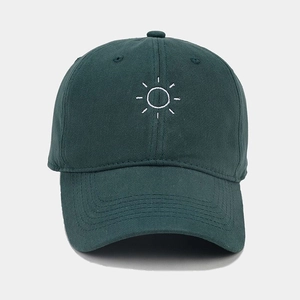Detailed embroidery of a white sun on a dark green cotton twill baseball cap
