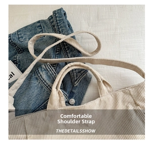 Detail view of beige corduroy tote bag showing textured shoulder straps and fabric finish