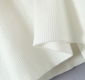 Primer plano macro de la textura de punto acanalado blanco de un vestido con escote