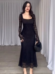 Close-up of elegant floral crochet lace texture on a black long-sleeved dress