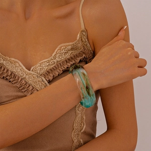 Macro shot of blue and brown marble resin bangle on a model wearing brown lace top