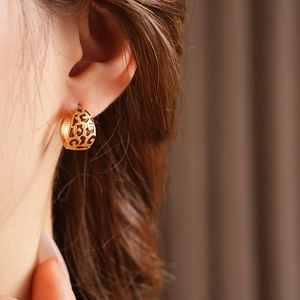 Close-up of gold leopard print hoop earring featuring an intricate hollow design
