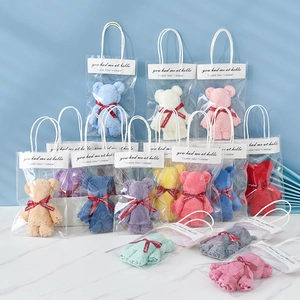 Macro detail of colorful coral fleece bear towels in clear gift bags with ribbons