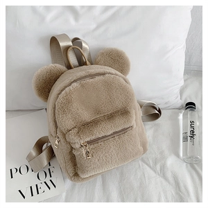 Detail of soft beige faux fur backpack featuring cute bear ears and golden zippers