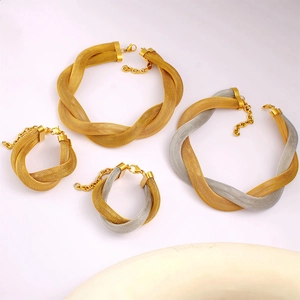 Detail of woven mesh texture and lobster clasp on gold and silver tone jewelry set