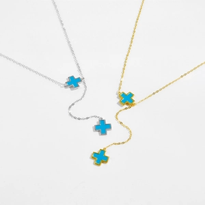 Detailed shot of gold and silver S925 cross necklaces with vibrant blue pendants
