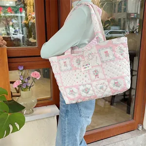 Close-up of pink quilted cotton tote bag with floral patchwork and bow details