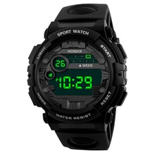 Macro shot of waterproof digital sport watch with green LED backlight display and resin band