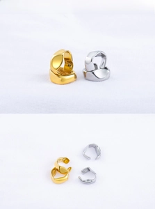 Polished gold and silver irregular geometric ear clips on white textured fabric