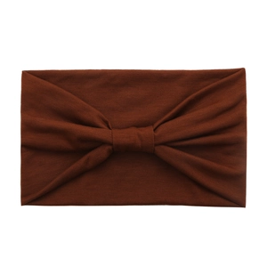 Detail view of brown wide cotton yoga headband with a soft knot bow in knit texture