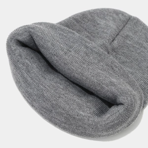 Close-up of a dark grey knit beanie showing thick ribbed texture and soft fabric detail