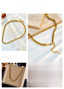 Detail of flat golden snake chain necklace with lobster clasp and extension chain
