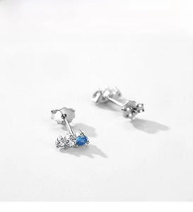 Macro shot of S925 silver stud earrings with blue zircon and white gemstone accents