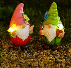 Detail von Gartenzwerg-Statuen im Erdbeer- und Melonen-Design, die nachts sanft leuchten