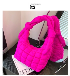 Detail of rose red quilted cloud handbag with square stitching and gold zipper closure